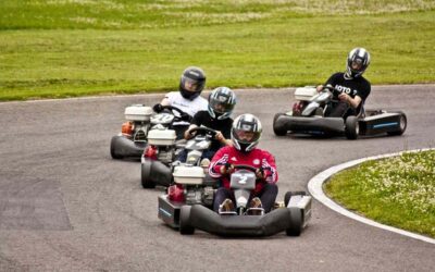 Enfants pilotant des karts rouges et blancs sur un circuit de loisir engazonné