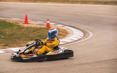 Un coureur en combinaison jaune pilote un kart sur piste courbe