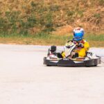 Kart sur piste avec conducteur en combinaison jaune